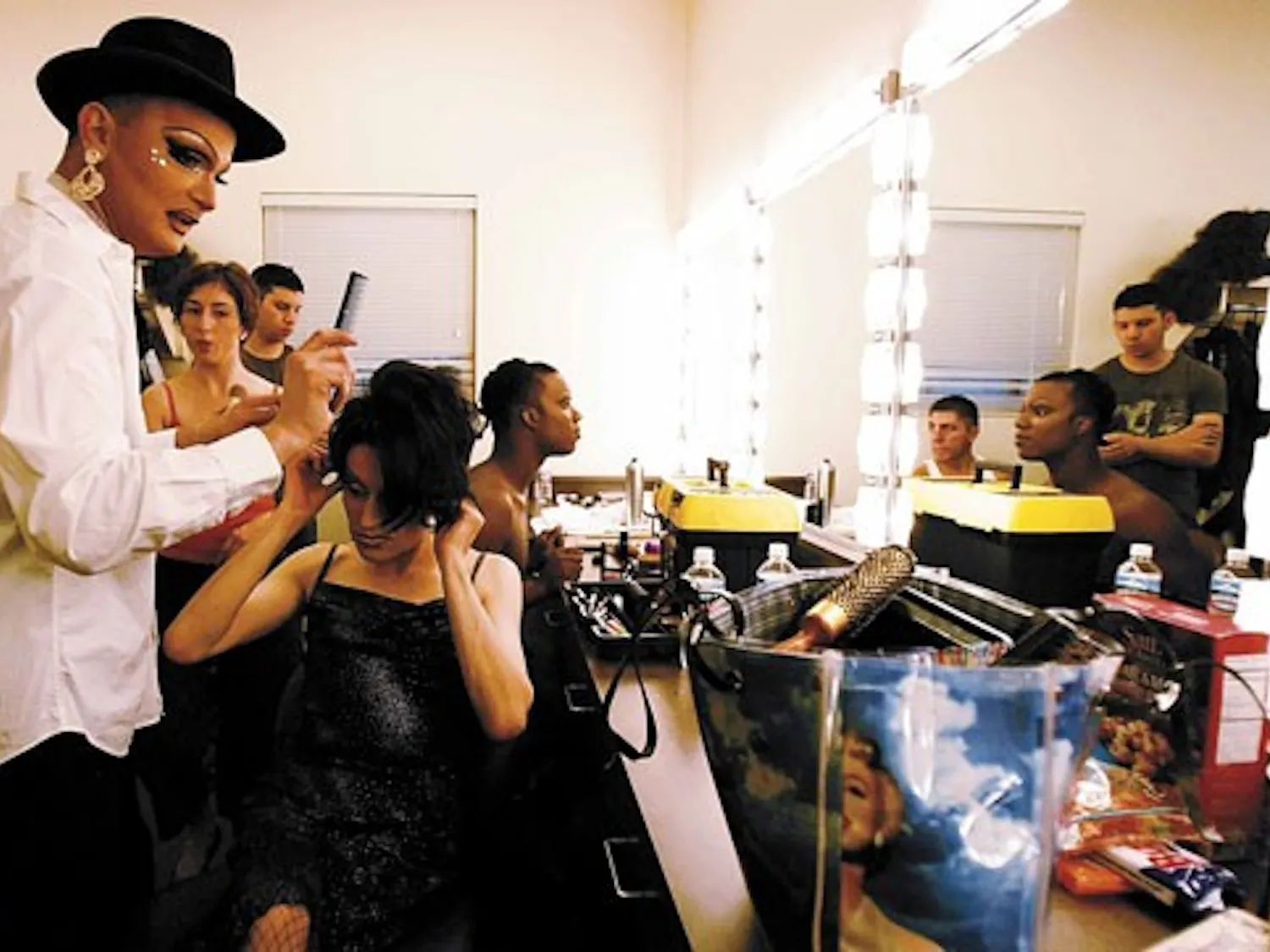 Drag queen Cassandra De La Noche, left, does drag queen Victoria Velasquez's hair in a dressing room while preparing to perform during the "Come Out, Come Out, Wherever You Are: Paris is Burning . Life is a Masquerade" show at the National Hispanic Cultur