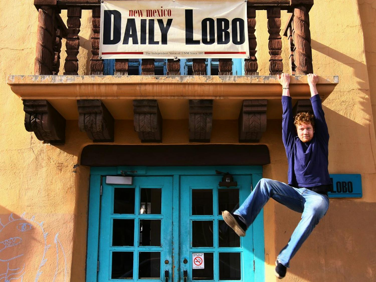 Pat Lohmann, new Daily Lobo editor-in-chief, dangles from a balcony at Marron Hall. Lohmann wants to focus on investigative reporting and transparency during his tenure as editor.