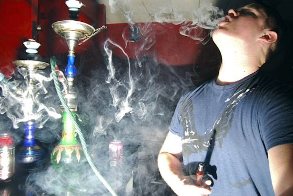 Zach Carlson smokes at Relux Hookah Lounge on May 14. 