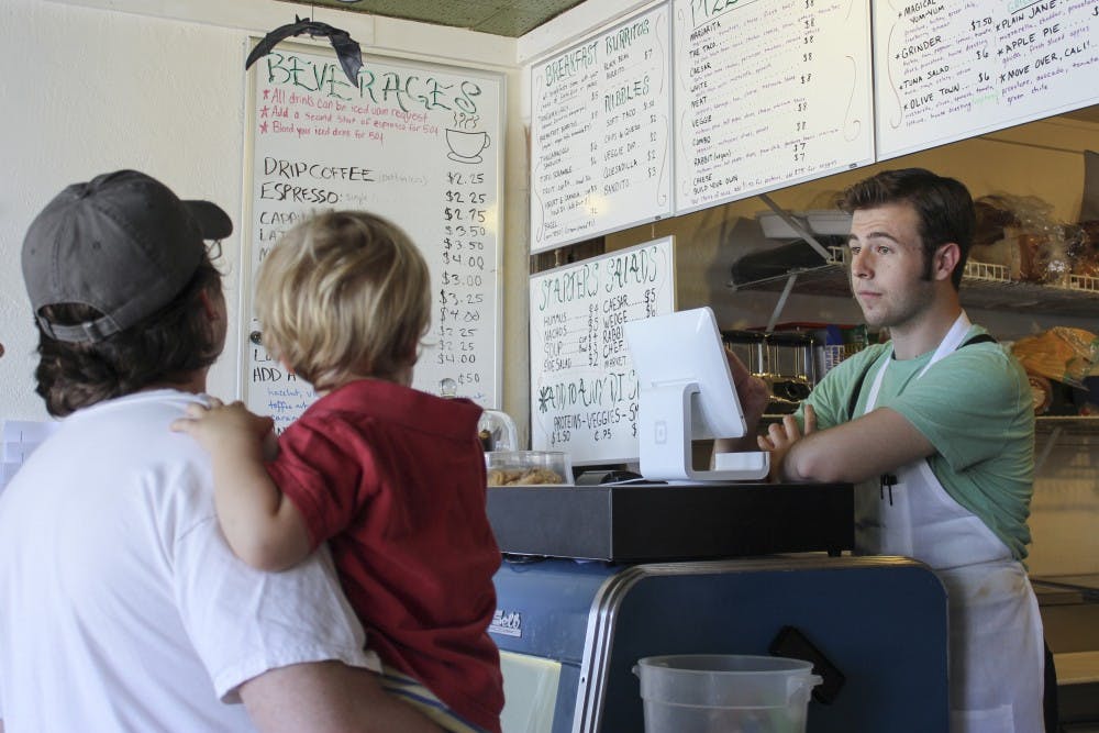 Bryan Lambe, a staff member at the Witchs Brew, helps a customer on Saturday afternoon. The Witch's Brew offers its Kick Down Coffee program that allows customers to pay for a homeless persons lunch. 