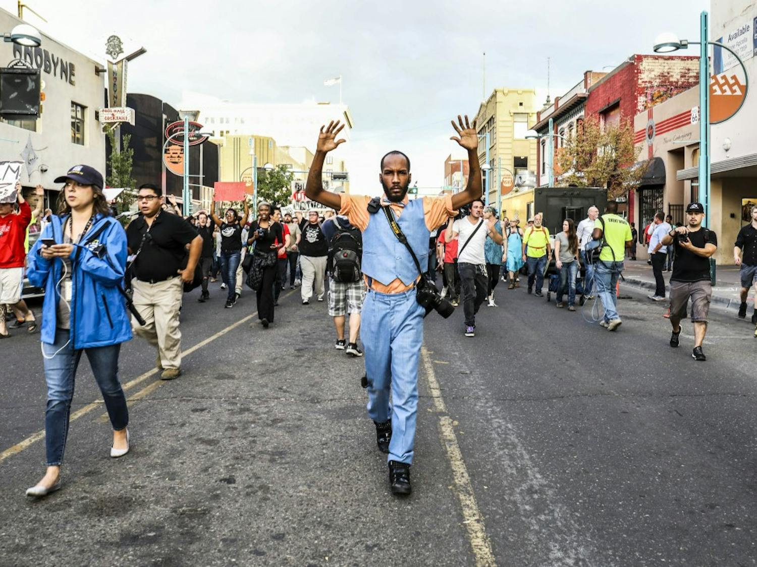 Arthur Bell raises his arms as protesters chant “hands up don’t shoot” during the Black Lives Matter March on Friday, Sept. 22, 2017. Participants marched through Downtown before stopping at the roundabout on 8th Street.&nbsp;