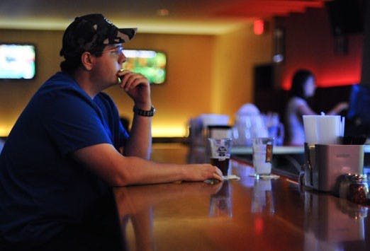 Student Oran Griego drinks a beer at Brickyard Pizza on Thursday night. More than 100 university presidents across the U.S. have petitioned to lower the legal drinking age to 18. 