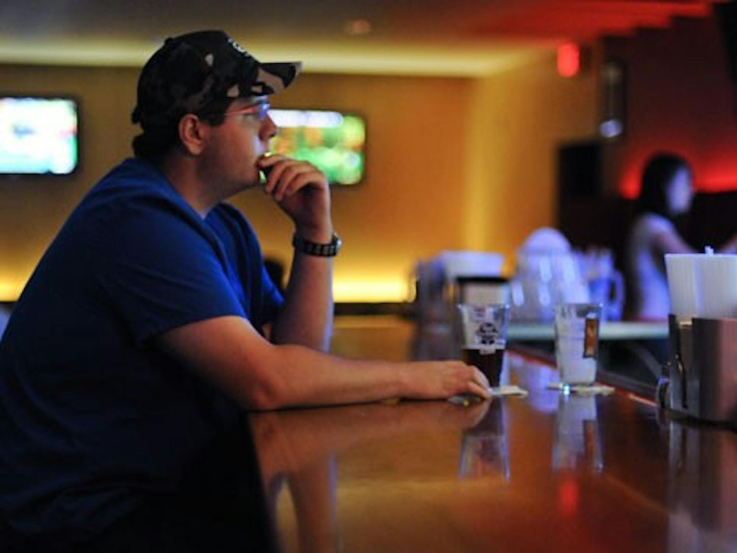 Student Oran Griego drinks a beer at Brickyard Pizza on Thursday night. More than 100 university presidents across the U.S. have petitioned to lower the legal drinking age to 18.