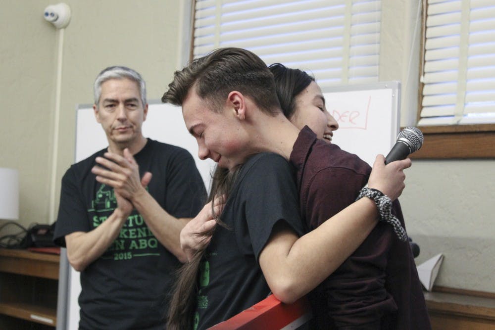 Taylor Chavez, founder of Teen Start-up Weekend, embraces Gavin Moseher after Chavez gives Moseher an award for his work mentoring students for the event Sunday at FatPipe Abq in downtown Albuquerque. Teen Start-up Weekend focuses on helping young entrepreneurs develop a business plan.
