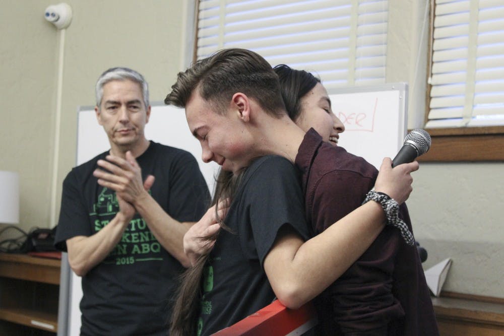 Taylor Chavez, founder of Teen Start-up Weekend, embraces Gavin Moseher after Chavez gives Moseher an award for his work mentoring students for the event Sunday at FatPipe Abq in downtown Albuquerque. Teen Start-up Weekend focuses on helping young entrepreneurs develop a business plan.
