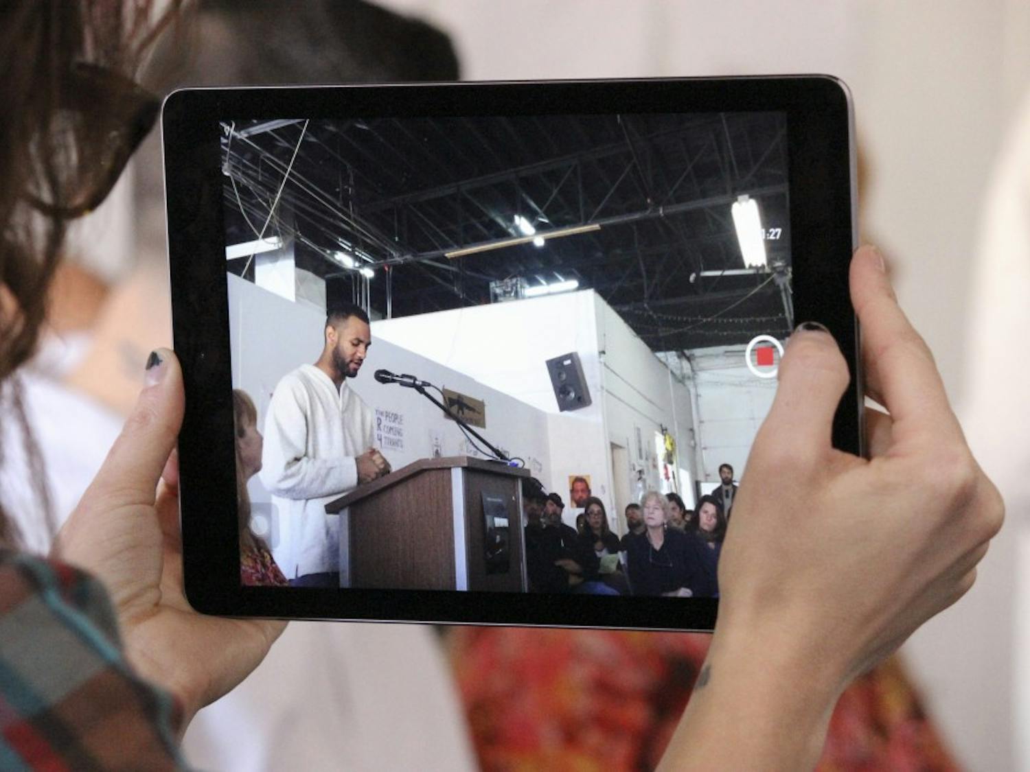 Jill Jurkiewicz records Andrew Nances speech for the Albuquerque Peoples Tribunal on Police Brutality meeting on Saturday afternoon at Kinley Avenue. Nance was one of many speakers who spoke about the impact police brutality has on the community.