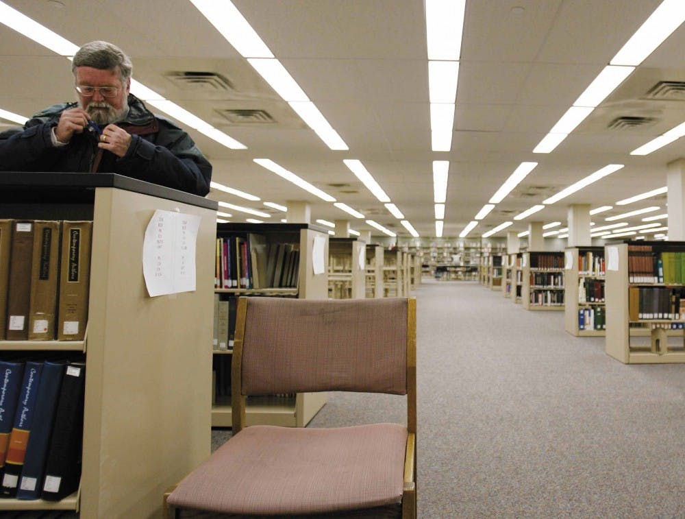 History professor Jake Spidle looks at a reference book in the reopened reference section in Zimmerman Library on Tuesday. The east wing of the library reopened Tuesday for the first time since the fire in April.