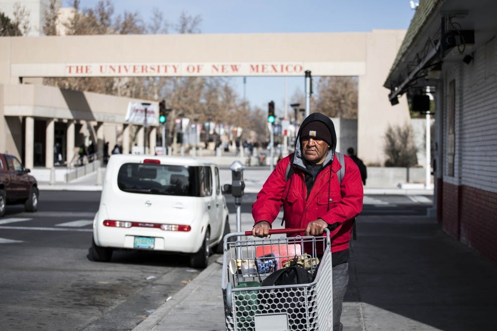 An Albuquerque homeless man transports his belongings down Central Avenue via shopping cart on the evening of Jan. 17, 2018.