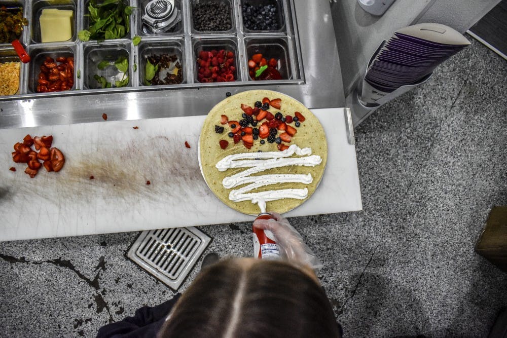 An employee spreads whipcream on a crepe at Crepeology, a creperia founded by three University of New Mexico alumnus.