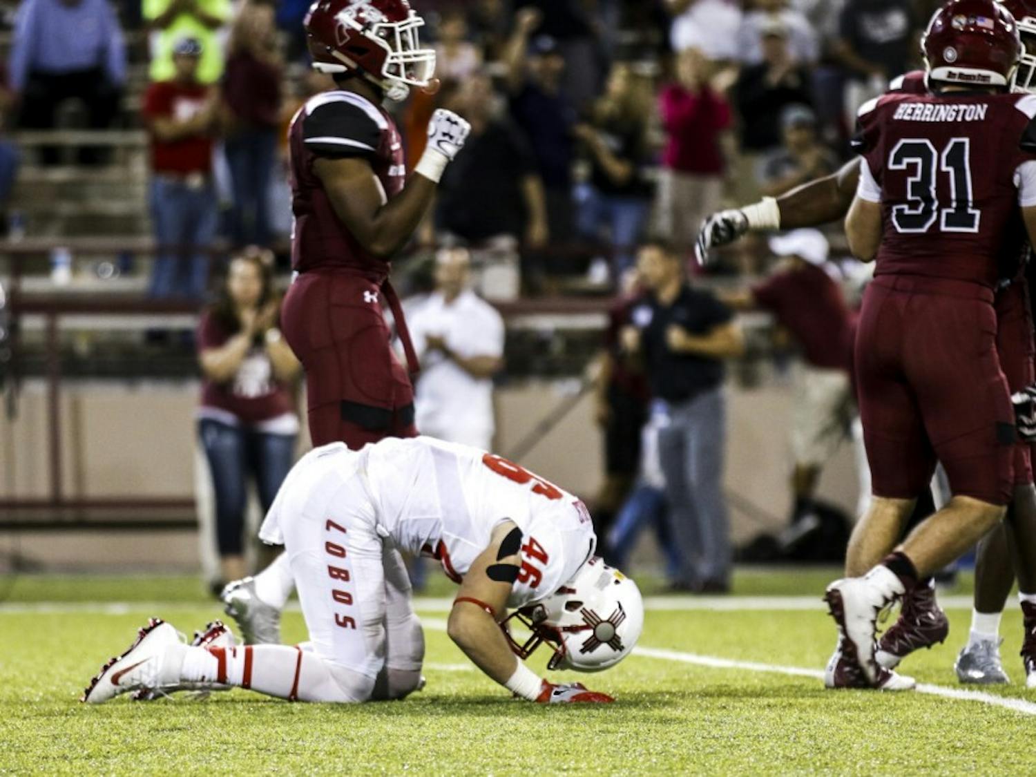 Senior line backer Dakota Cox hits the turf&nbsp;as NMSU players celebrate around him Saturday, Sept. 10, 2016 in Las Cruces, New Mexico.&nbsp;The Lobos lost to the Aggies for the first time&nbsp;since 2011 by a score of 32-31.&nbsp;&nbsp;