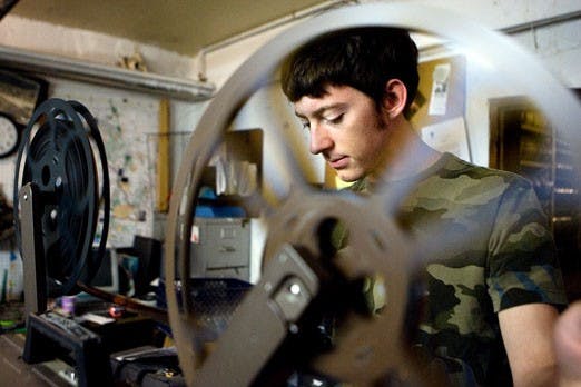 Brian Gillespie of Basement Films places a reel onto a projector at the Harwood Art Center.