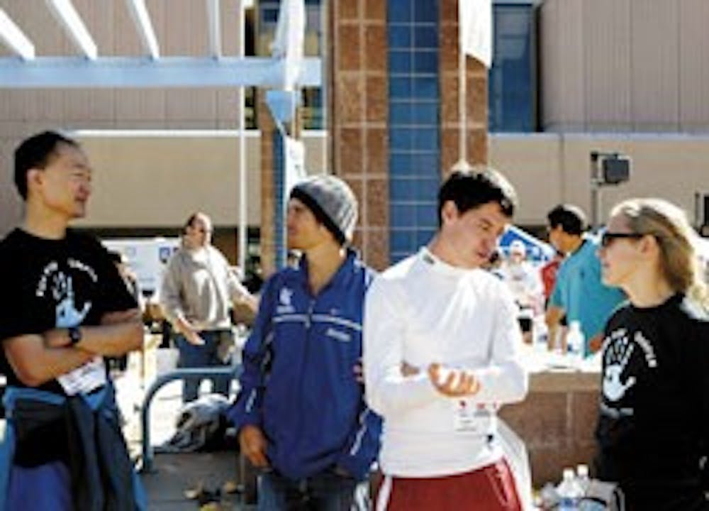 Students and faculty members from UNM's law school, from left, professor Norman Bay, students Kris Hougton and Ben Ortega and professor Jennifer Moore cool down after running in the Duke City Marathon held Downtown on Sunday.