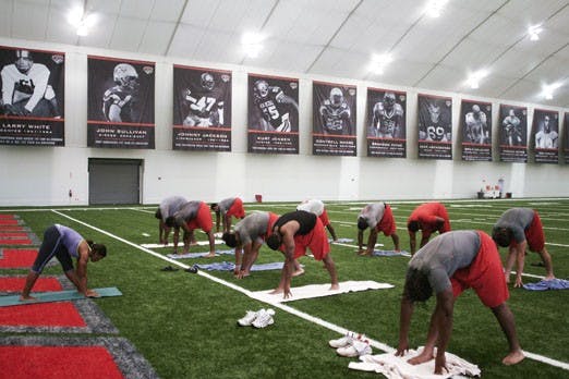 	UNM football players Jaymar Latchison, left, and Josh Taufalele meditate during one of the Lobos’ yoga classes at the Indoor Practice Facility on July 22.

