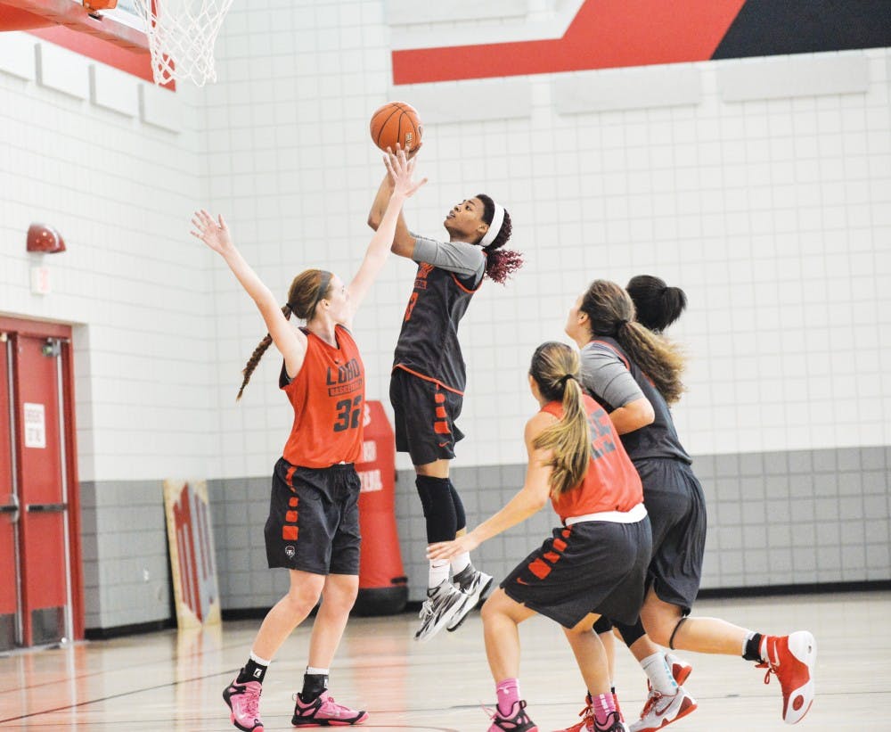 Forward Khadijah Shumpert reaches past her teammates for a shot during their second practice of the season Tuesday October 6, 2015. The Lobos face off with Western New Mexico November 4 at WisePies Arena. 