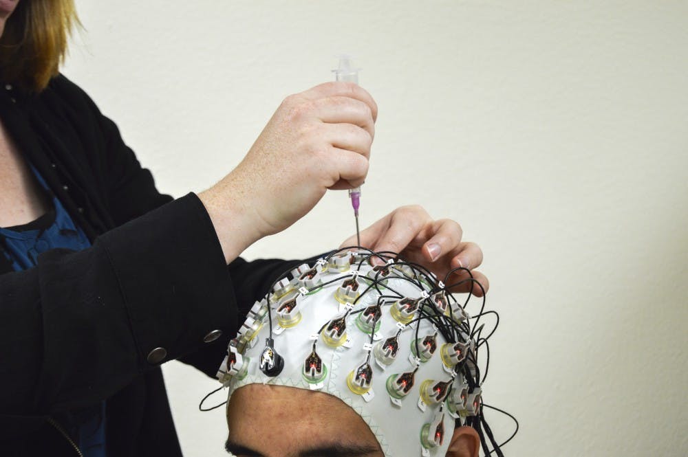 Sarah Salway demonstrates on Ronnie Pedroncelli the experimental phase of research that is being done at the Department of Psychiatry and Behavioral Sciences that focuses on the connection between alcohol and domestic violence. The research is broken into two phases, experimental and questionnaires.