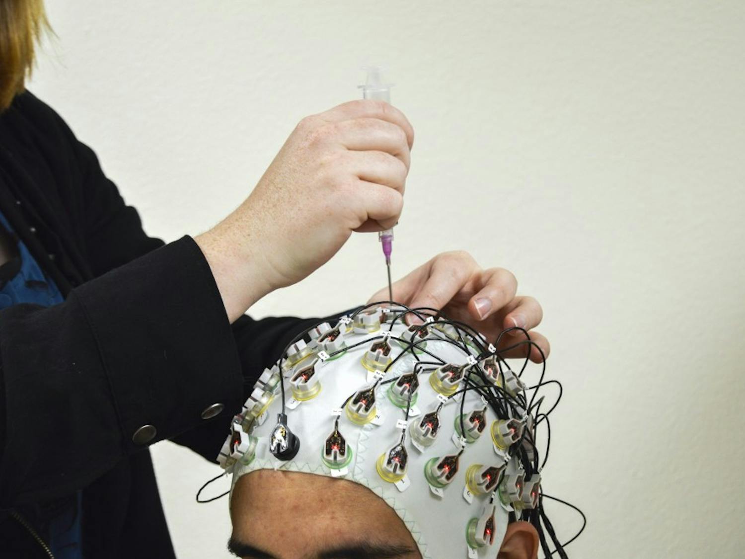 Sarah Salway demonstrates on Ronnie Pedroncelli the experimental phase of research that is being done at the Department of Psychiatry and Behavioral Sciences that focuses on the connection between alcohol and domestic violence. The research is broken into two phases, experimental and questionnaires.