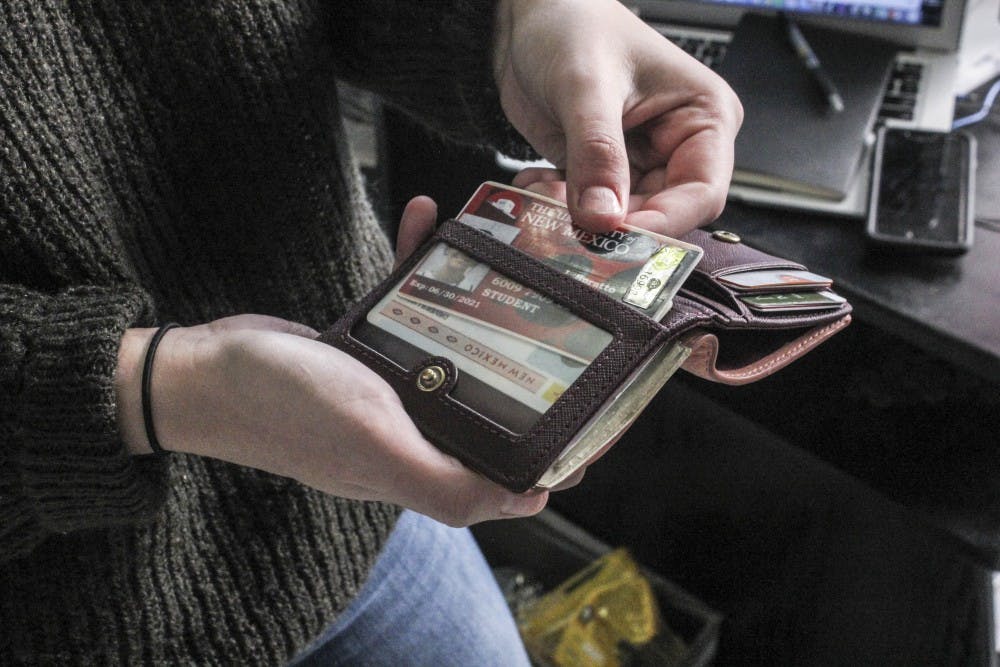 A UNM student pulls out her UNM ID on Jan. 28, 2017.