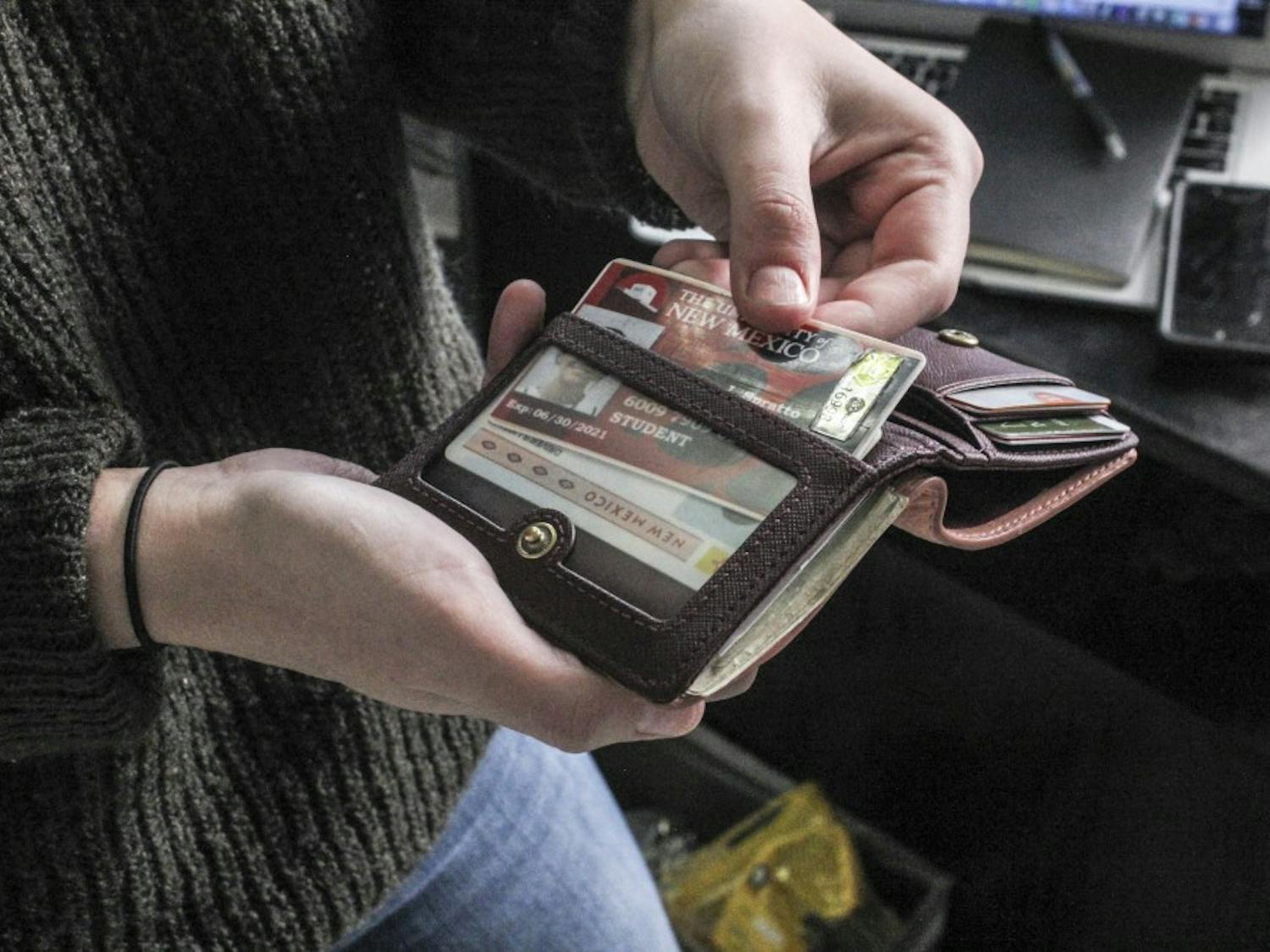 A UNM student pulls out her UNM ID on Jan. 28, 2017.
