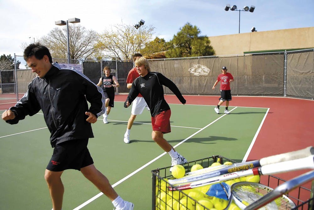 UNM tennis players Chris Parkes, left, and Miles Bugby, center, warm up for practice Wednesday at the UNM Tennis Complex. 