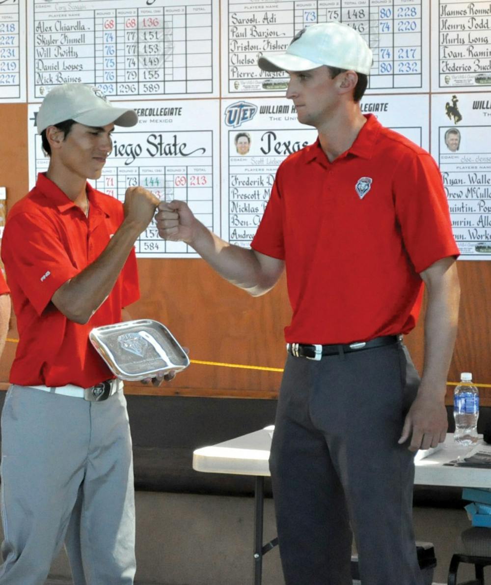 Senior Joseph Abella fist bumps assistant coach Drew McGee after the Lobos tournament at UNM’s Championship Course. The Lobos received first place at the William H. Tucker intercollegiate golf tournament Saturday Sept. 26, 2015.