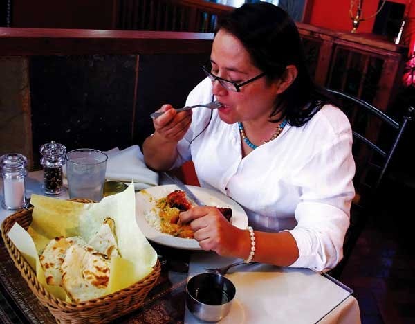 UNM graduate student Mary Rea eats tandoori chicken from Rasoi's lunch buffet Tuesday on 110 Yale Blvd. S.E. The restaurant opened Oct 7. 