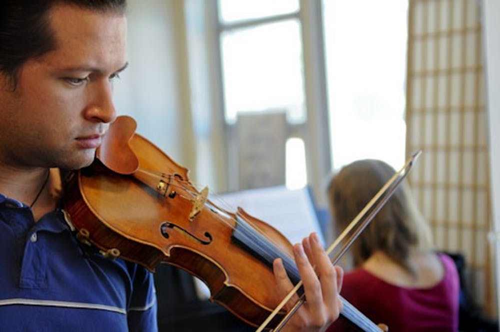 Karles McQuade plays violin with his accompanist Hope Lanctot in the Fine Arts Building on Tuesday.