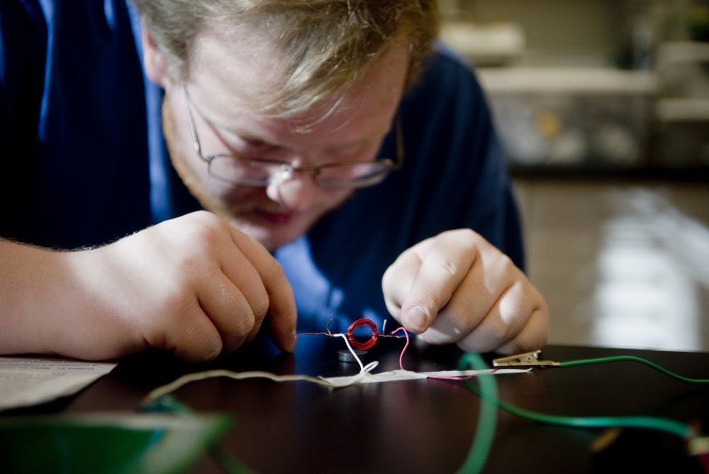 Lincoln Ross fine tunes his electromagnetic motor that he created out of simple materials during a natural science class held at the Science Math Learning Center Thursday morning. Ross and other students learn how to make hands on science activities so they are better equipped to teach&nbsp;K-8 students natural science fundamentals.&nbsp;