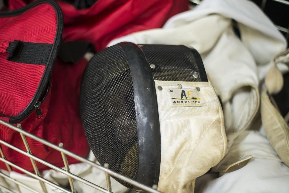 A fencing mask sits in a cart filled with supplies that the University of New Mexico Fencing Club uses during their meets at Johnson Gym.