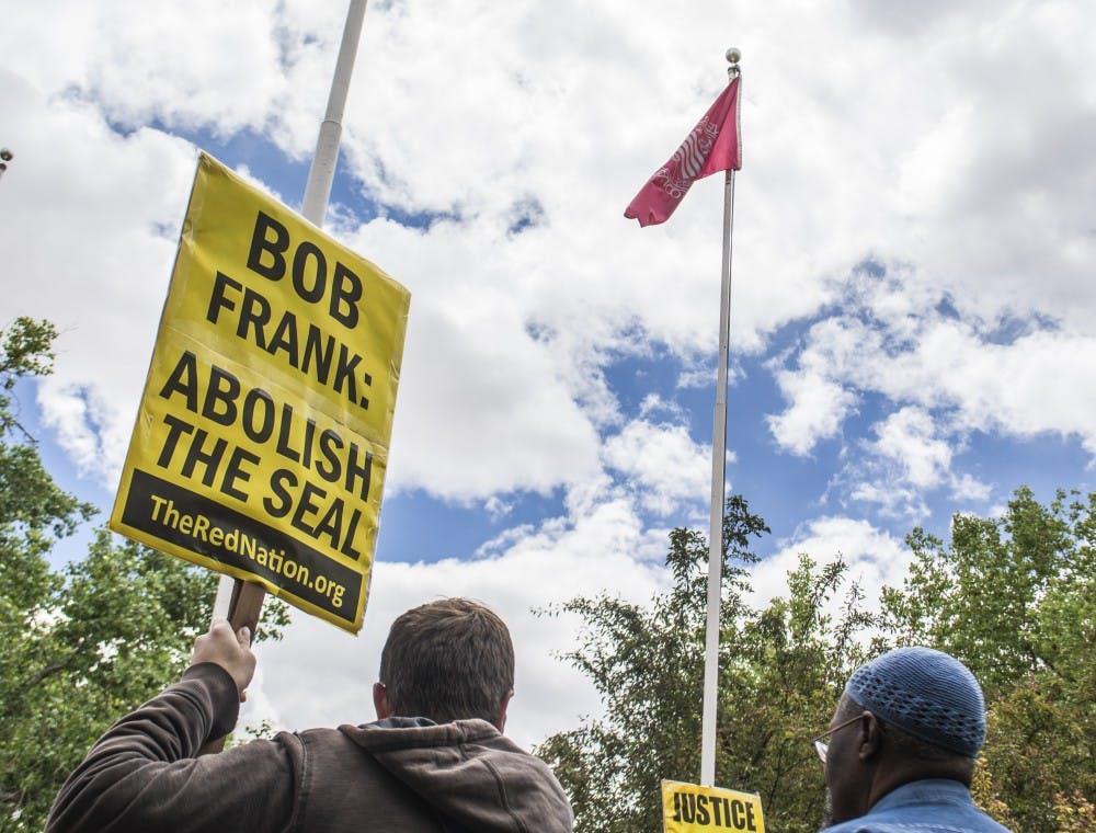Students, faculty and other members of the community met Friday afternoon outside of Scholes Hall in a protest against the UNM seal. The seal depicts a conquistador, which, according to some student groups, is a harsh reminder of the impacts of European colonization.