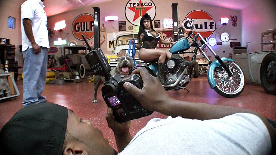 	Matt Campbell, a UNM art graduate, checks the back of his camera as Karma poses with Chrome, two pit bulls, for Campbell’s Pits and Chicks Calendar. 
