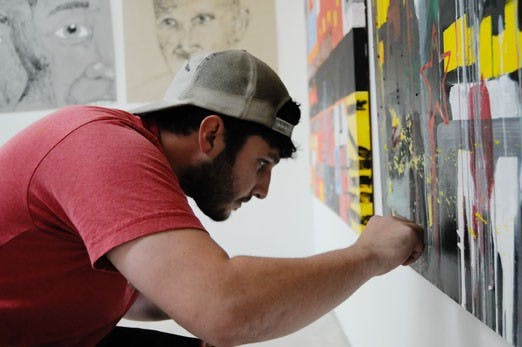 Gabriel Alarid works on a painting in his studio Monday. 