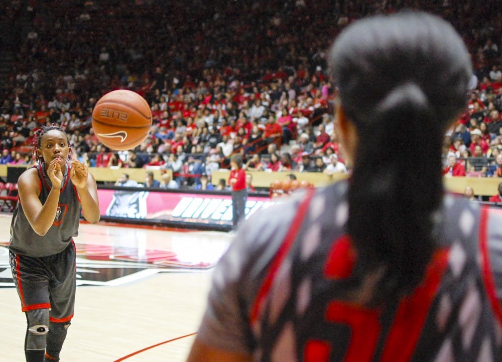 Lobo redshirt senior center Ebony Walker, left, passes to junior guard Brea Mitchell during Friday’s Lobo Howl at the Pit. Mitchell advanced to the final round of the 3-point shooting contest that night, beating out freshman guard Cherise Beynon 16-12.