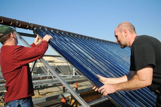 Peter Vorobieff, left, and Dan Fisher install a solar panel on top of the Mechanical Engineering Building on Sept. 30. Sens. Barack Obama and John McCain advocate alternative energy solutions, including solar, wind and nuclear power. 