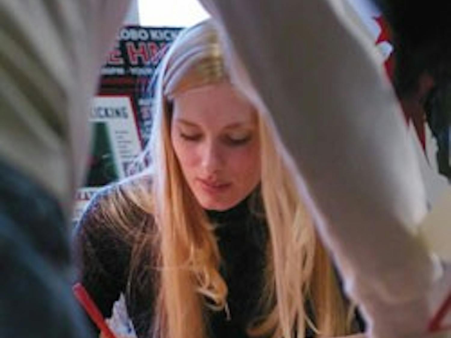 Former UNM kicker Katie Hnida signs a copy of her book, Still Kicking: My Journey as the First Woman to Play Division I Football, for Dick Webb on Thursday at the Bookstore.