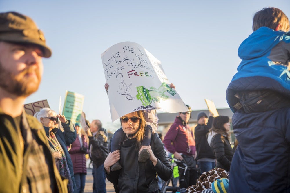Light shines on protestors gathering on Yale Boulevard before making their way to the Albuquerque International Sunport on Sunday, Jan. 29, 2017. Demonstrators came together in a national movement against President Donald Trump's executive order banning immigration from several countries.&nbsp;