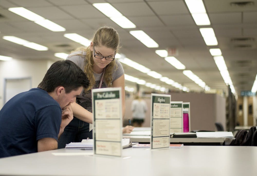 Tia Reid, a CAPS tutor, helps a student at the algebra and pre calculus table on the second floor of Zimmerman Library. CAPS tutors are found at different locations on campus through out the week depending on time and subject matter. 