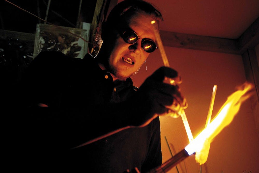Glassblower Niles Mahlman heats a glass rod to add color to an ornament at Studio Broadway at 1814 Broadway Blvd. S.E. on Saturday. Mahlman rents the studio to teach glassblowing classes.