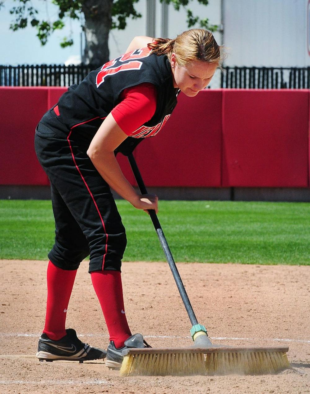 	Kerry Hodgins brushes off a base at the UNM Softball Complex, after the Lobos were defeated 9-5 by Colorado State on Sunday