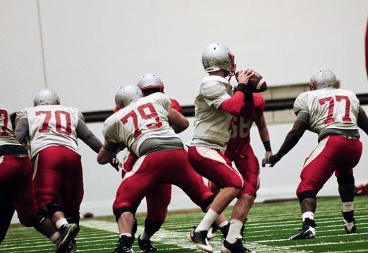 Members of the Lobos' offensive line block for freshman quarterback B.R. Holbrook during a scrimmage Saturday at UNM's Indoor Practice Facility.