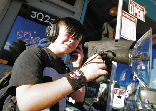 Twelve-year-old Dwight Everitt-Baldauf stands on the sidewalk while using a parabolic microphone in front of the Spy Shop on Central Avenue on Monday.