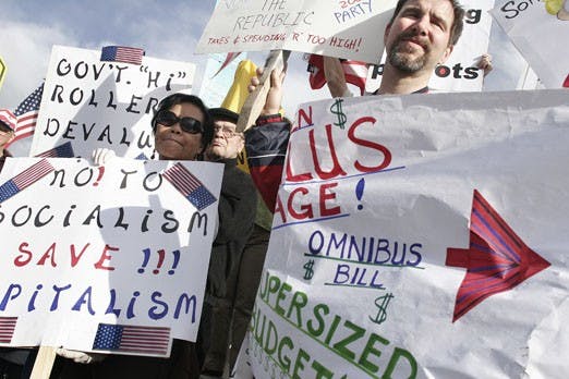 Protesters hold signs on Wednesday at the intersection of Montgomery and Louisiana boulevards in opposition to the deficit created by the government.