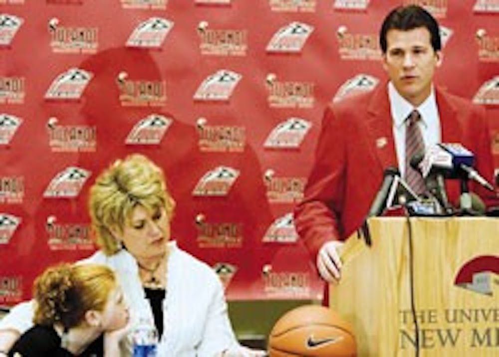 Men's basketball head coach Steve Alford answers a question during a press conference Friday in the SUB, while his daughter Kayla, left, and wife Tanya listen.