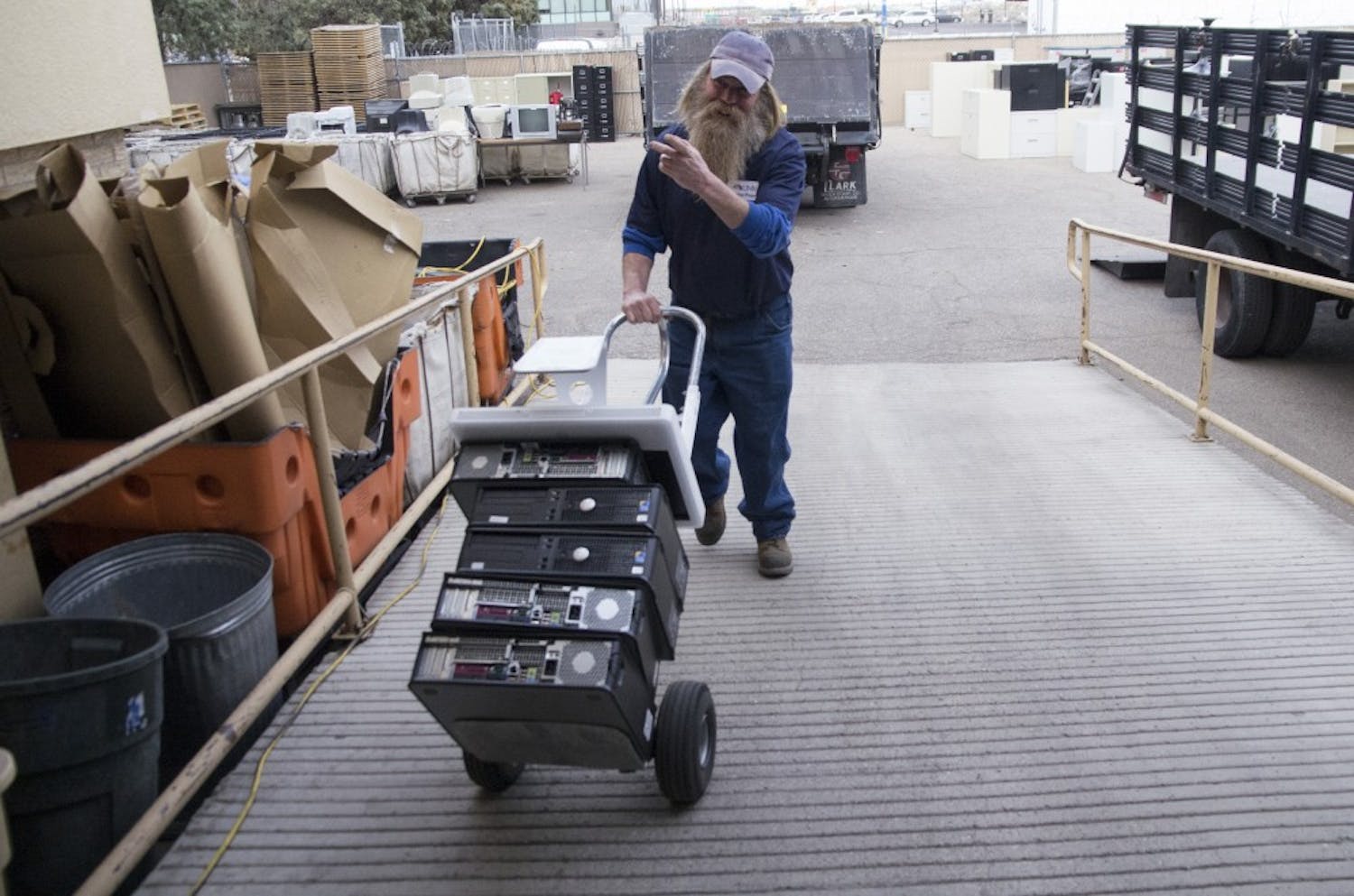 Patrick Smith, a three-year veteran at the UNM Surplus Department, moves old computer towers into a warehouse Monday. Smith and other workers at the department categorize and store all of UNM's unwanted equipment. 
