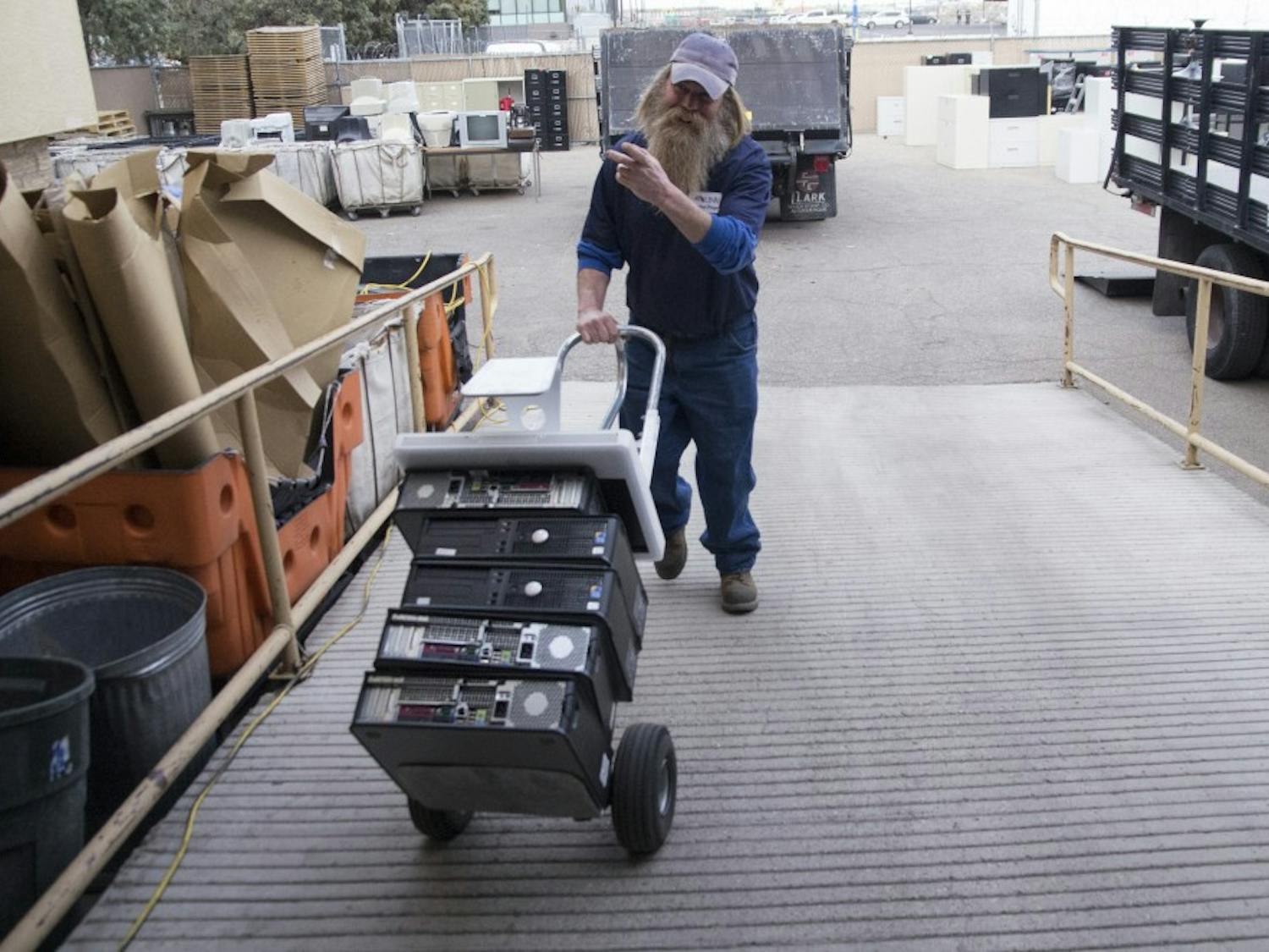 Patrick Smith, a three-year veteran at the UNM Surplus Department, moves old computer towers into a warehouse Monday. Smith and other workers at the department categorize and store all of UNM's unwanted equipment. 
