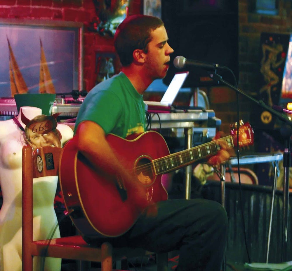 Ryan Newhill sings and plays guitar during Burt's Tiki Lounge's Hodgepodge Entourage variety show Monday. "It's our first time playing here," Newhill said. "We had a great time."