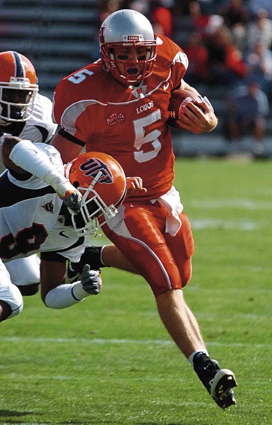 UNM quarterback Chris Nelson runs downfield before being knocked out of bounds by UTEP safety Quintin Demps during Saturday's game at University Stadium. 