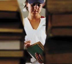 UNM student and Spring Storm volunteer Melissa Seiler sorts through boxes of books that were donated to Robert F. Kennedy Charter High School on Saturday. 