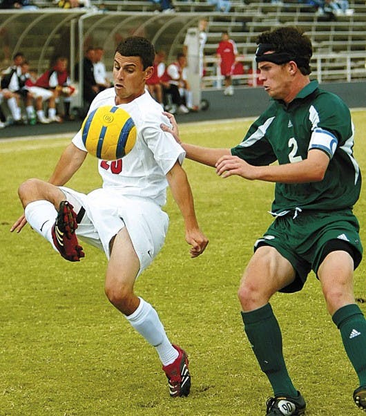 Lobo midfielder Joey Vitagliano, left, kicks the ball over the head of Sacramento State's Jesse Manton during Sunday's 1-0 overtime win at the UNM Soccer Complex.