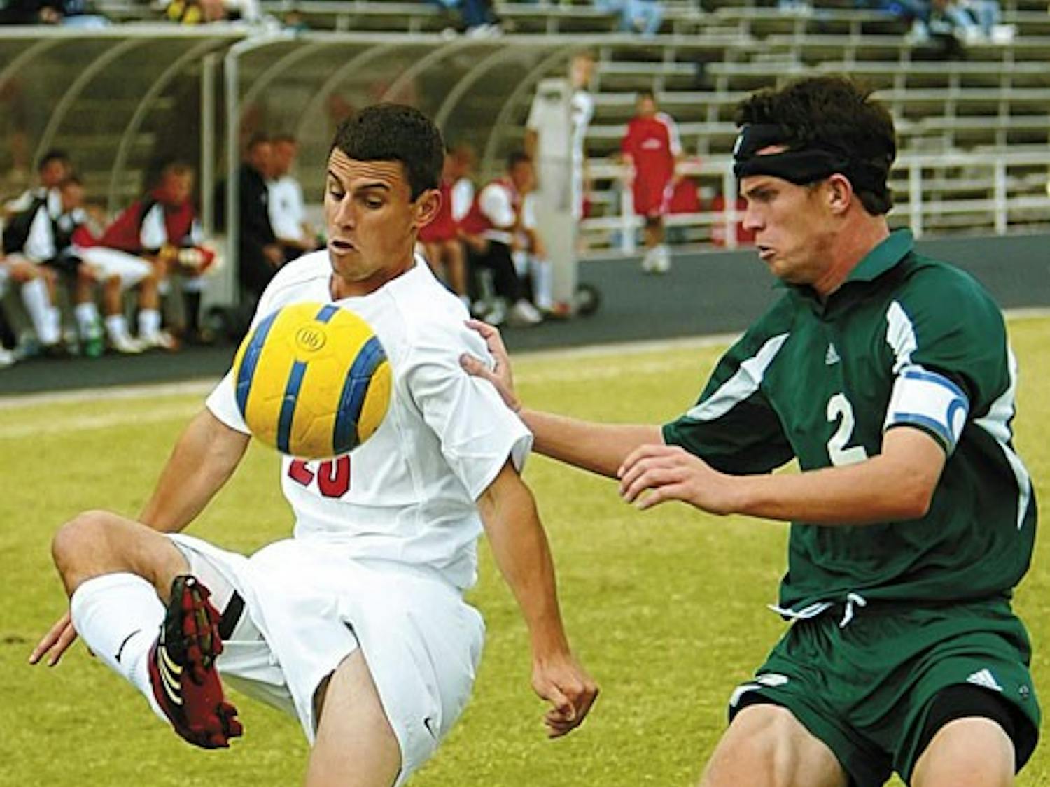 Lobo midfielder Joey Vitagliano, left, kicks the ball over the head of Sacramento State's Jesse Manton during Sunday's 1-0 overtime win at the UNM Soccer Complex.