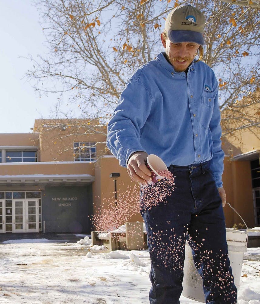 Physical Plant groundskeeper Carl Willcox spreads salt on the ice and snow near the SUB on Saturday.
